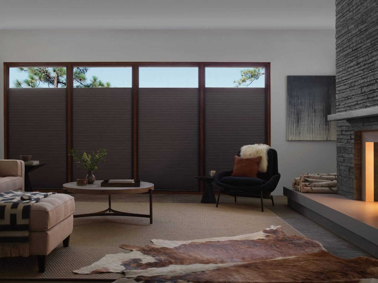 Home living room with a warm fireplace and windows covered with Hunter Douglas Duette® Cellular Shades near Ann Arbor, MI