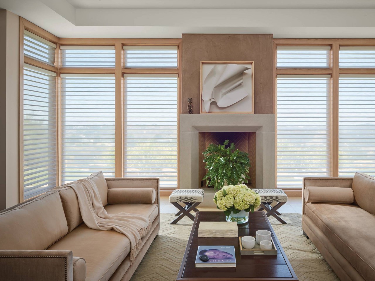 Picturesque home living room with many surrounding windows all outfitted with Hunter Douglas window treatments with PowerView® Automation at Delux Drapery & Shade Co. near Ann Arbor, MI