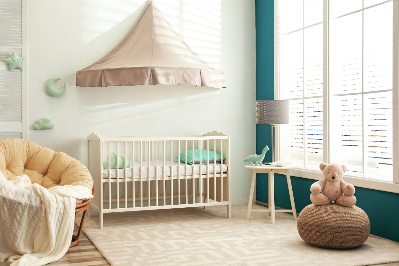 A neutral baby room with blue accents and cordless nursery blinds, creating a safer environment at Delux Drapery & Shade Co. near Ann Arbor, MI