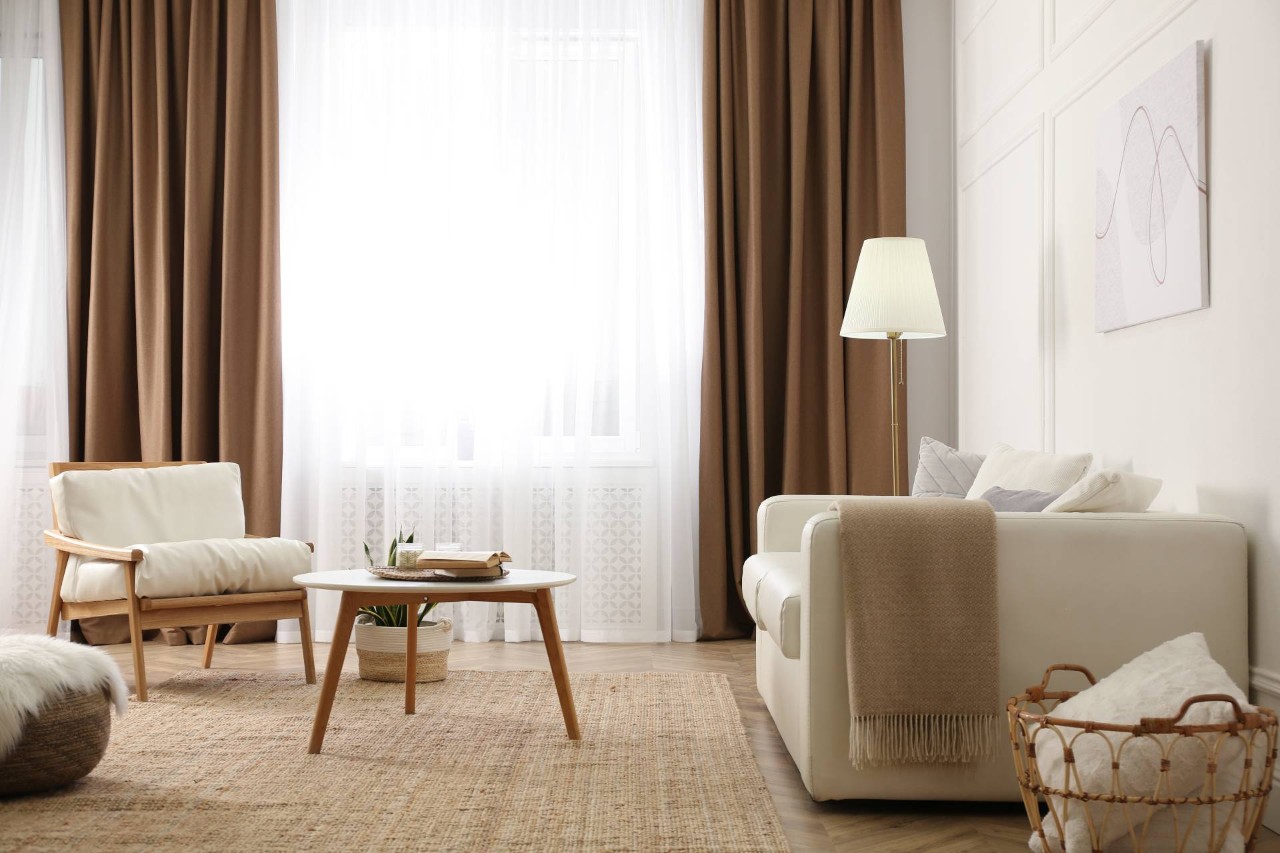 Dramatic and elegant brown drapes paired with sheer curtains in a cozy living room space at Delux Drapery & Shade Co. near Ann Arbor,(MI)